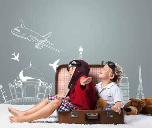 Two boys sitting in an open suitcase pretending to be airplanes